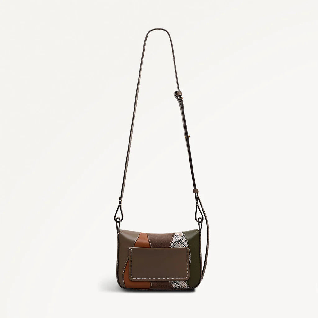 Patchwork-style handbag with a strap on a light gray background