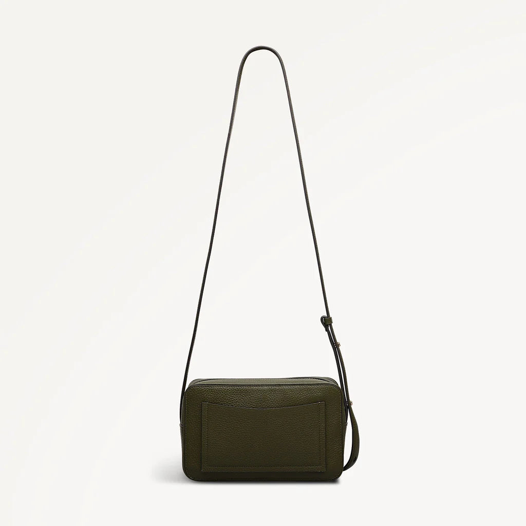 Green leather crossbody bag with a strap on a light gray background
