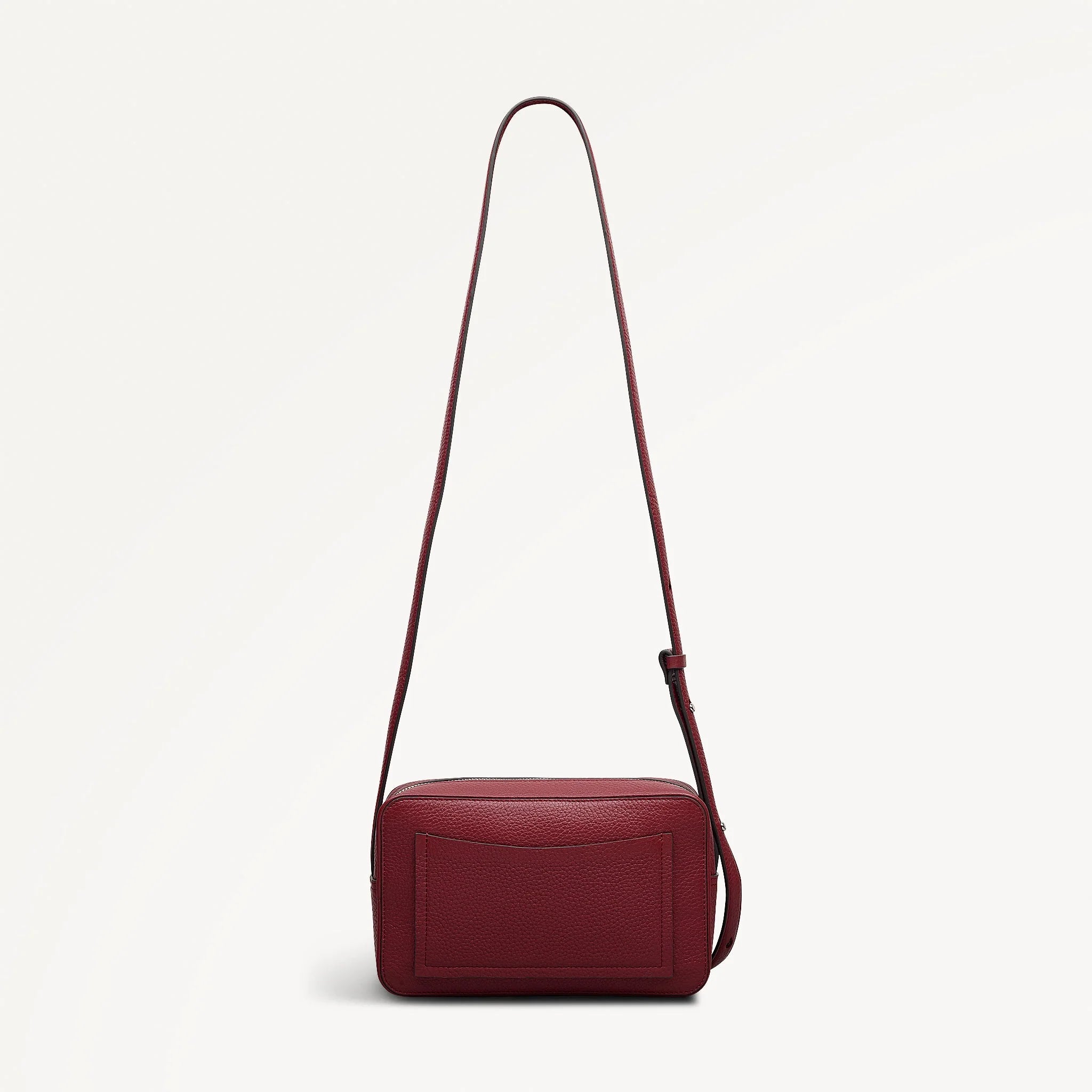 Red handbag with a strap on a light beige background