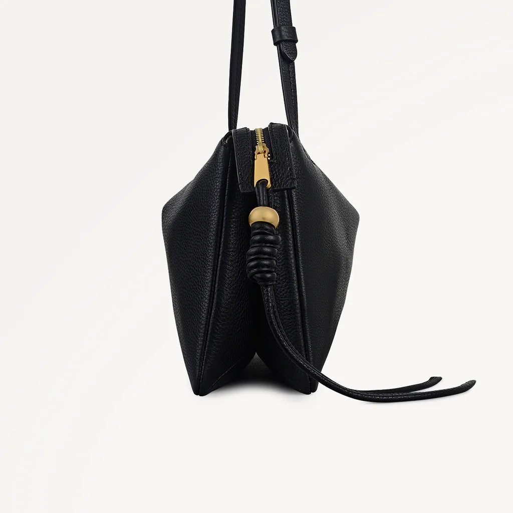 Black leather handbag with a gold zipper on a white background