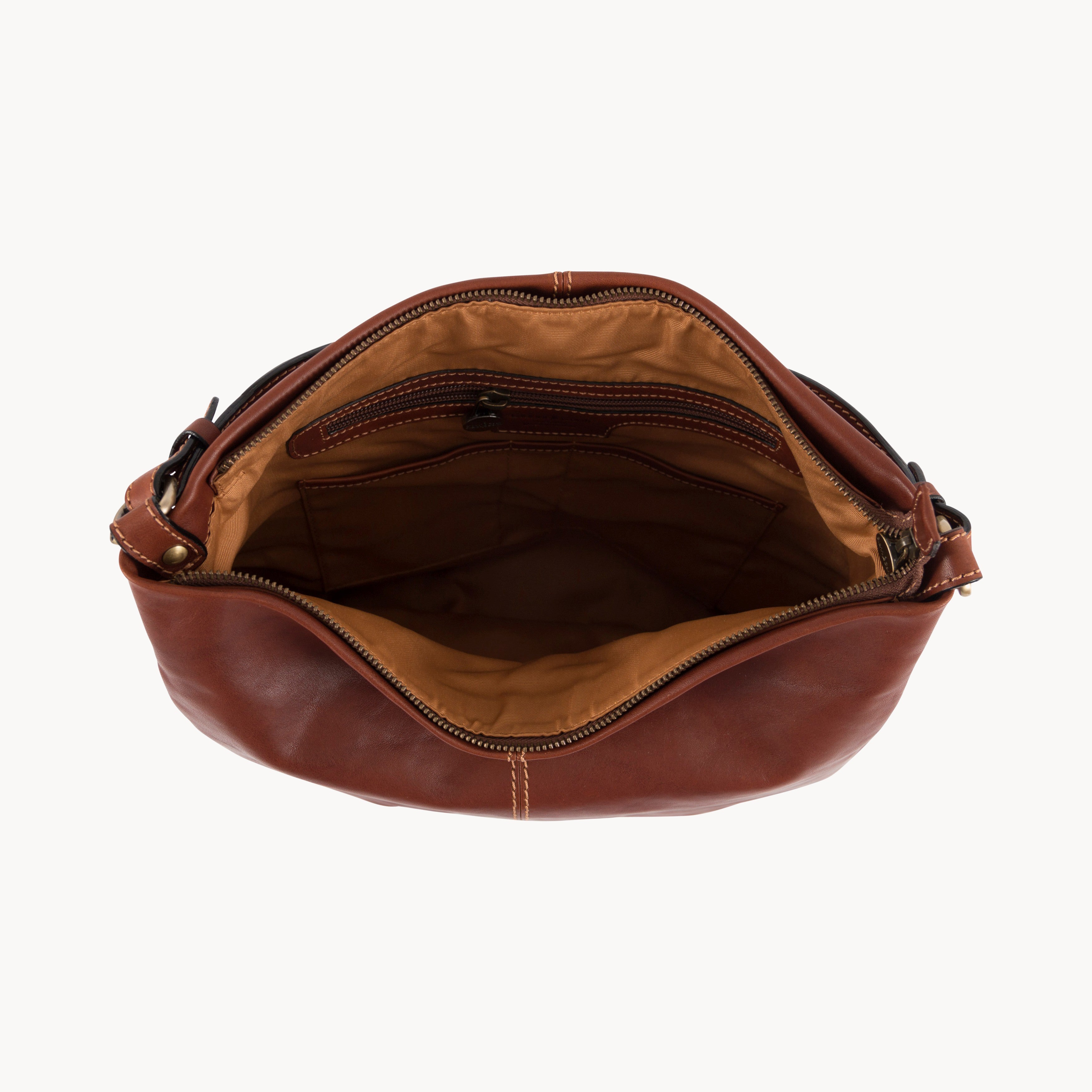 Brown leather bag with open top on a white background