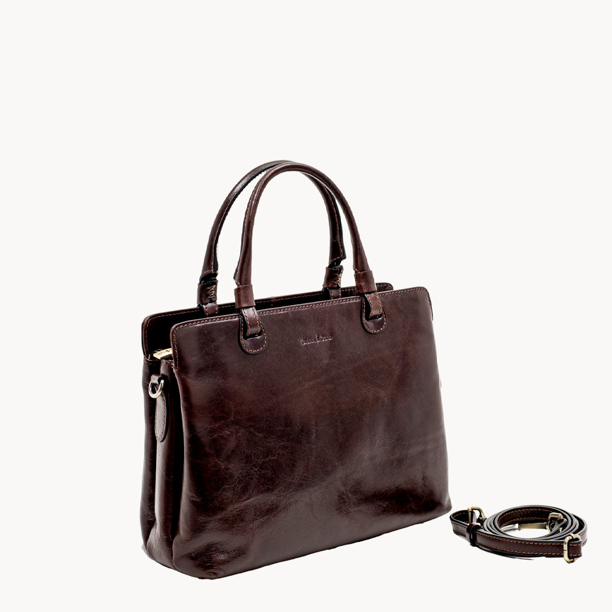 Brown leather handbag with a detachable strap on a white background