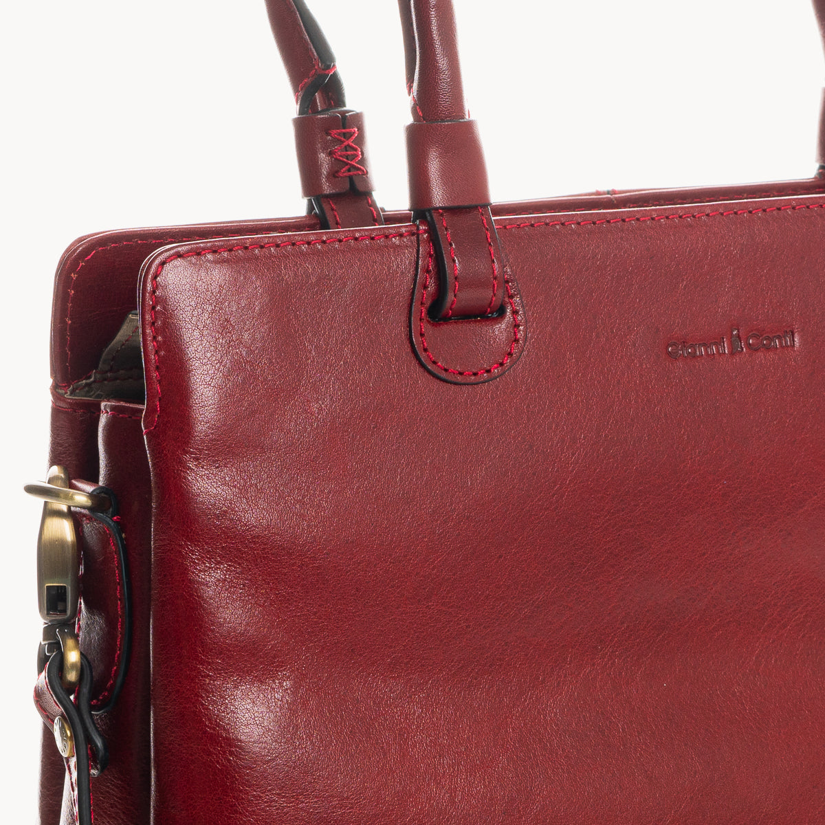 Close-up of a red leather handbag with visible brand name on a white background