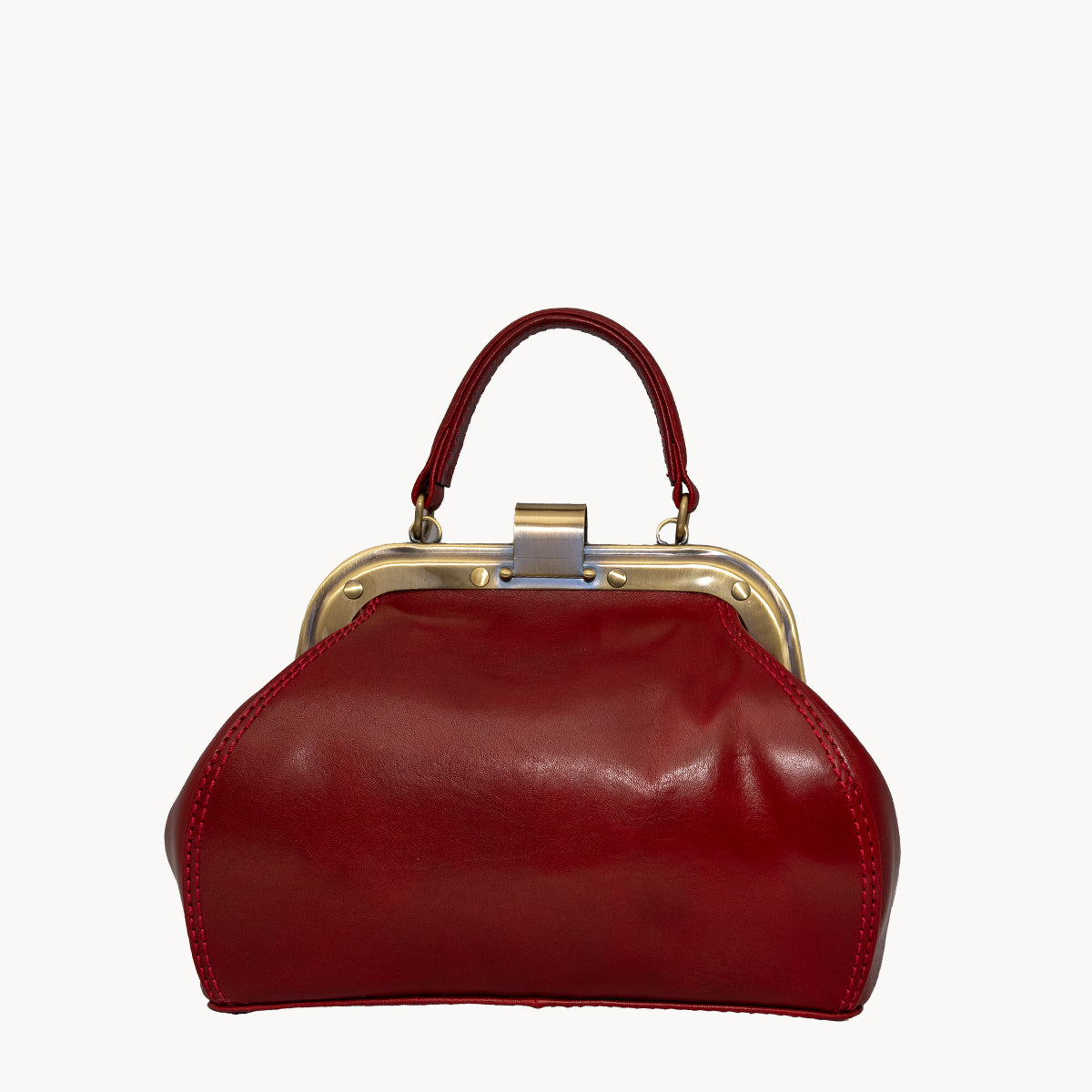 Red Gladstone style bag with metal clip opening and grad handle with detachable long strap.