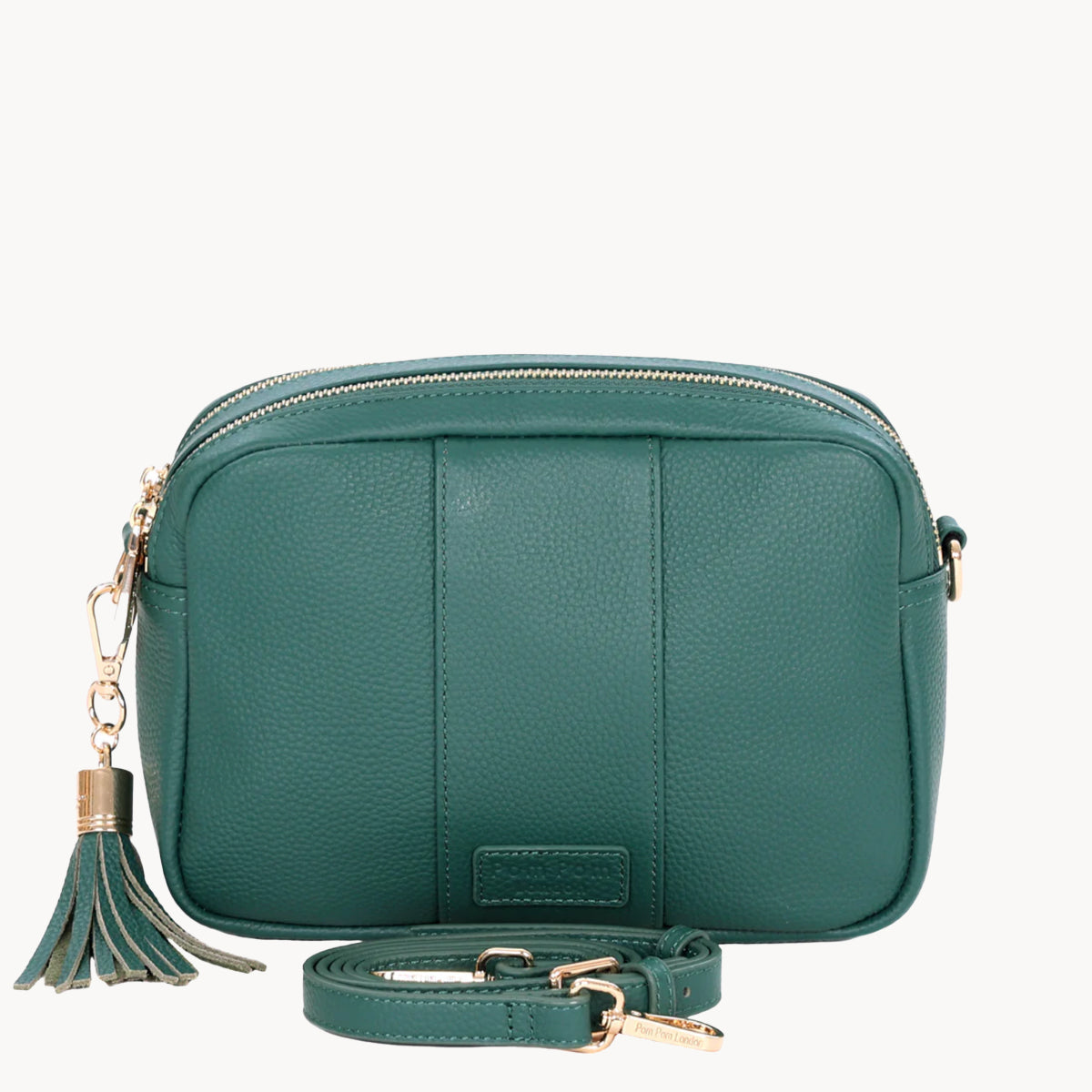 Green leather crossbody bag with a tassel on a white background