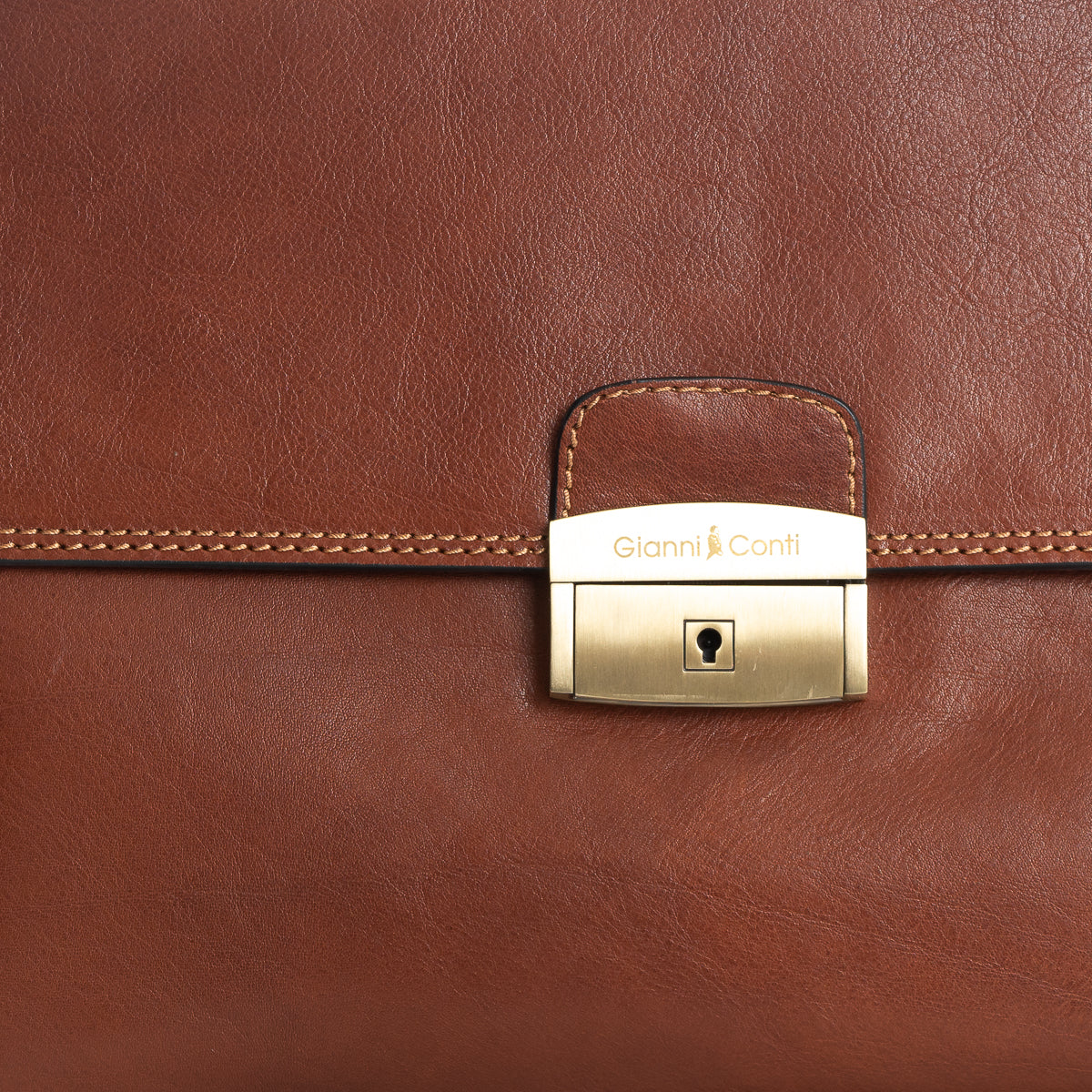 Close up of gold coloured front lock on tan leather briefcase