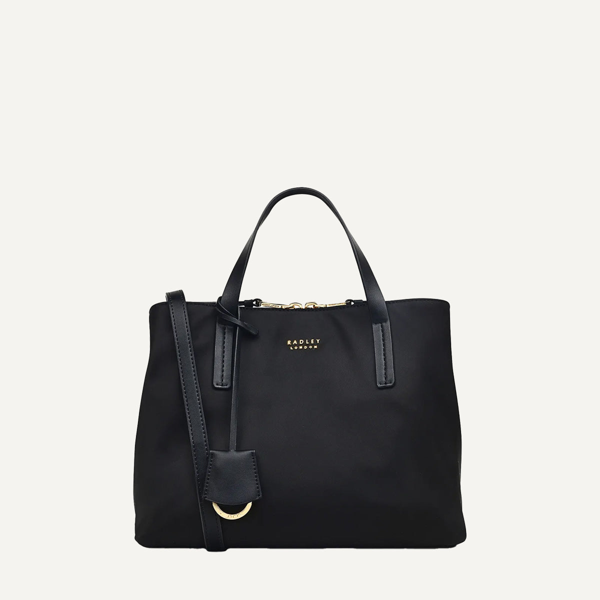 Black handbag with a strap on a light gray background