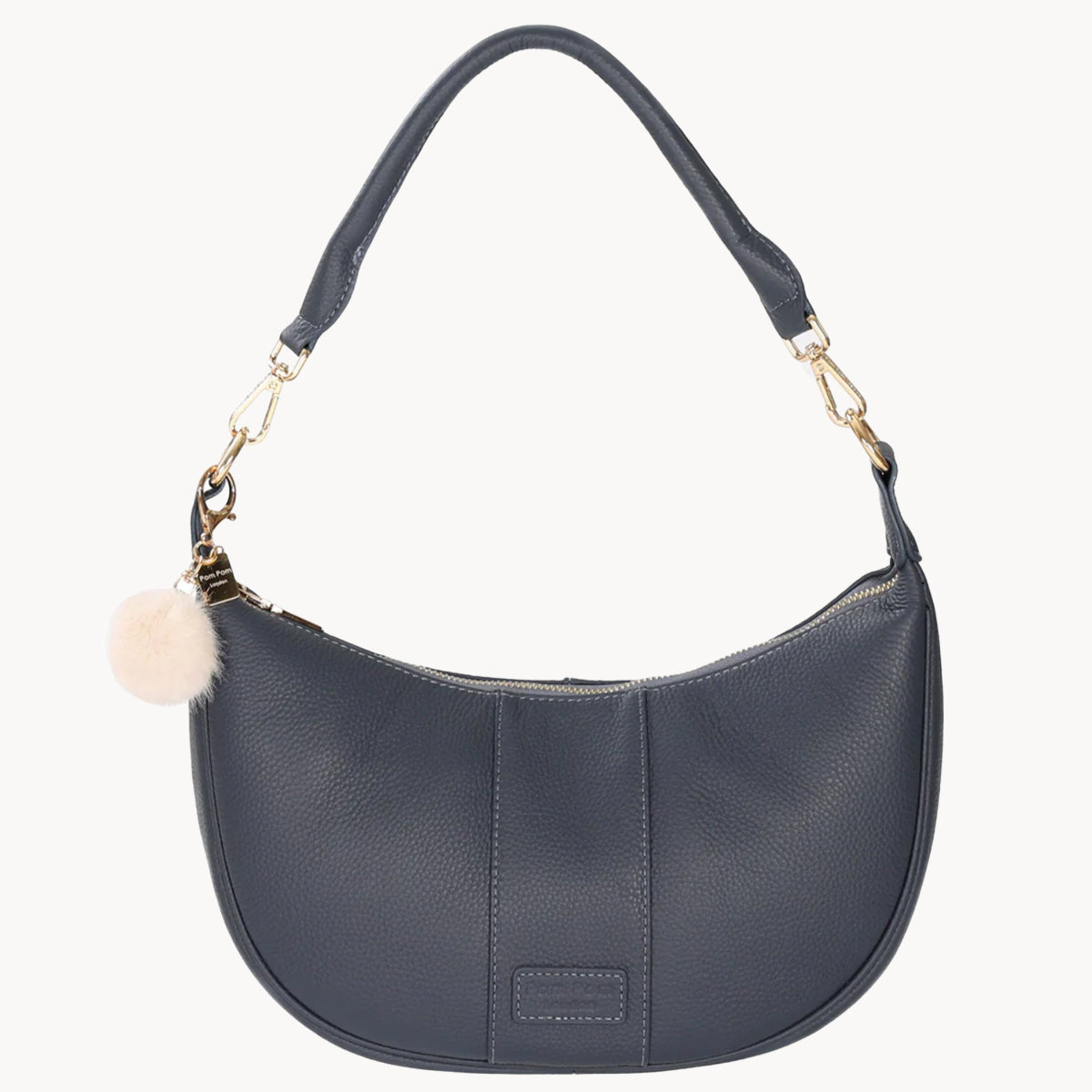 Navy handbag with a pom-pom detail on a white background