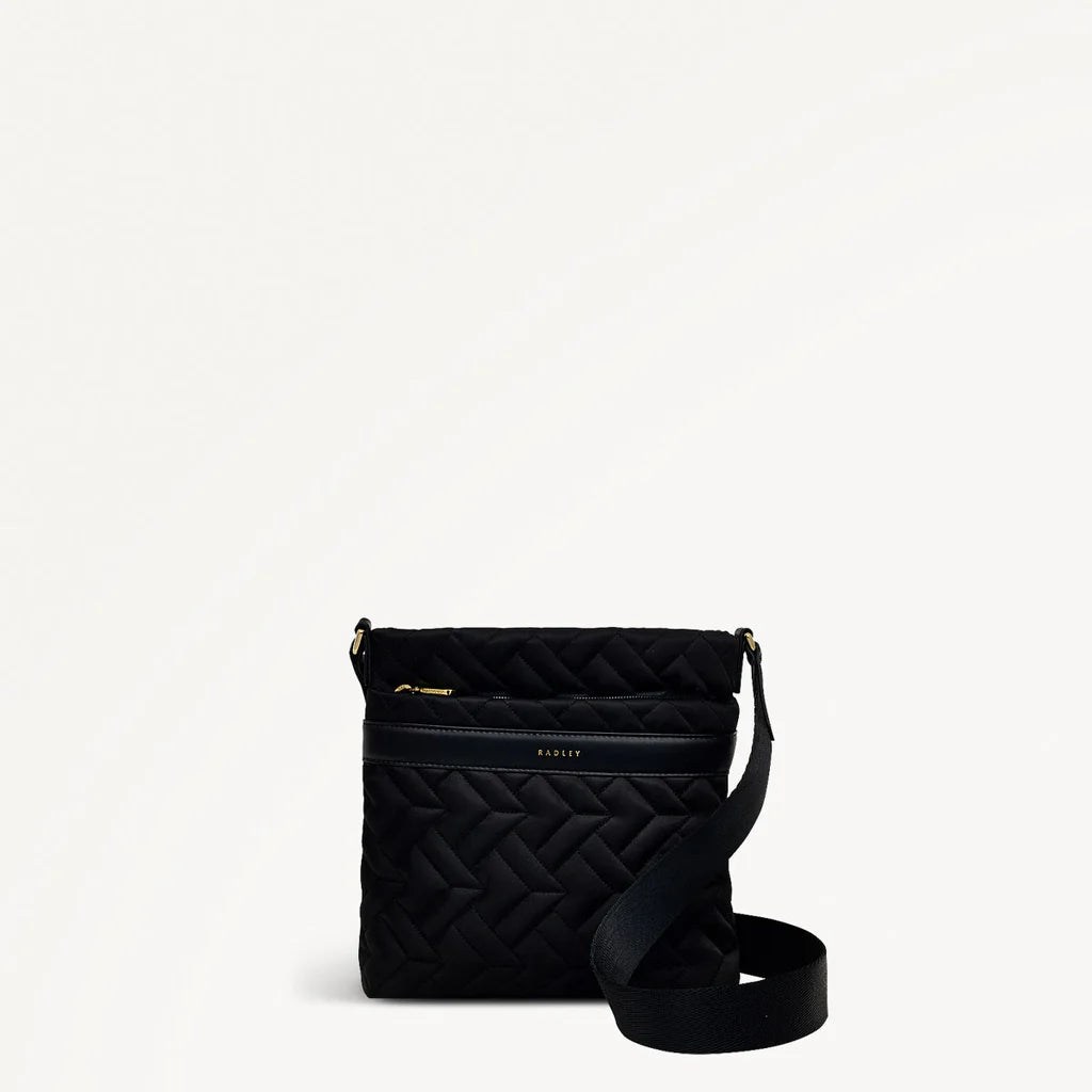 Black quilted handbag with a strap on a white background