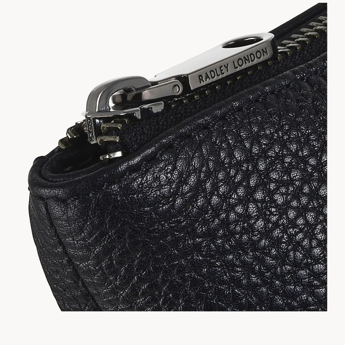 Black textured leather bag with a silver zipper featuring 'Radley London' branding.