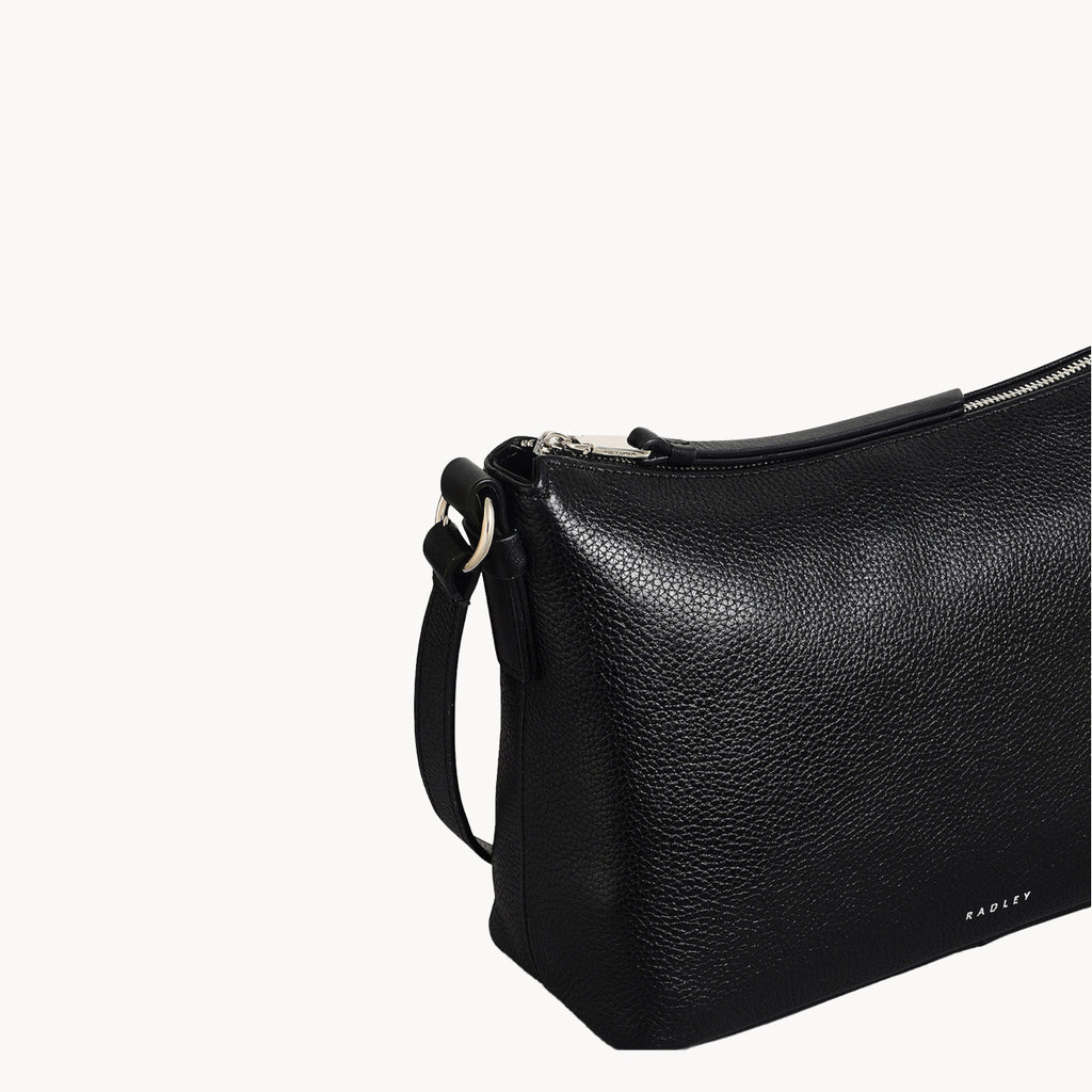 Black leather handbag with a strap on a white background