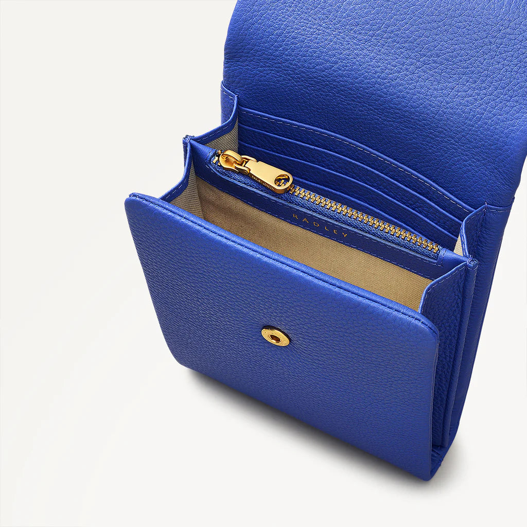 Blue leather wallet with gold zipper and button on a light gray background