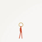 Small keychain with a gold ring and orange cord on a white background