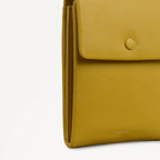 Yellow leather clutch bag with a visible brand logo on a white background