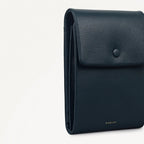 Navy blue leather wallet with Radley branding on a light gray background