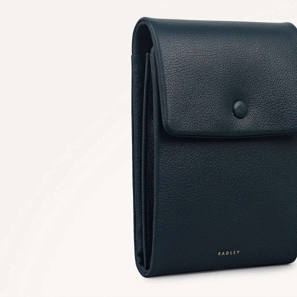 Navy blue leather wallet with Radley branding on a light gray background
