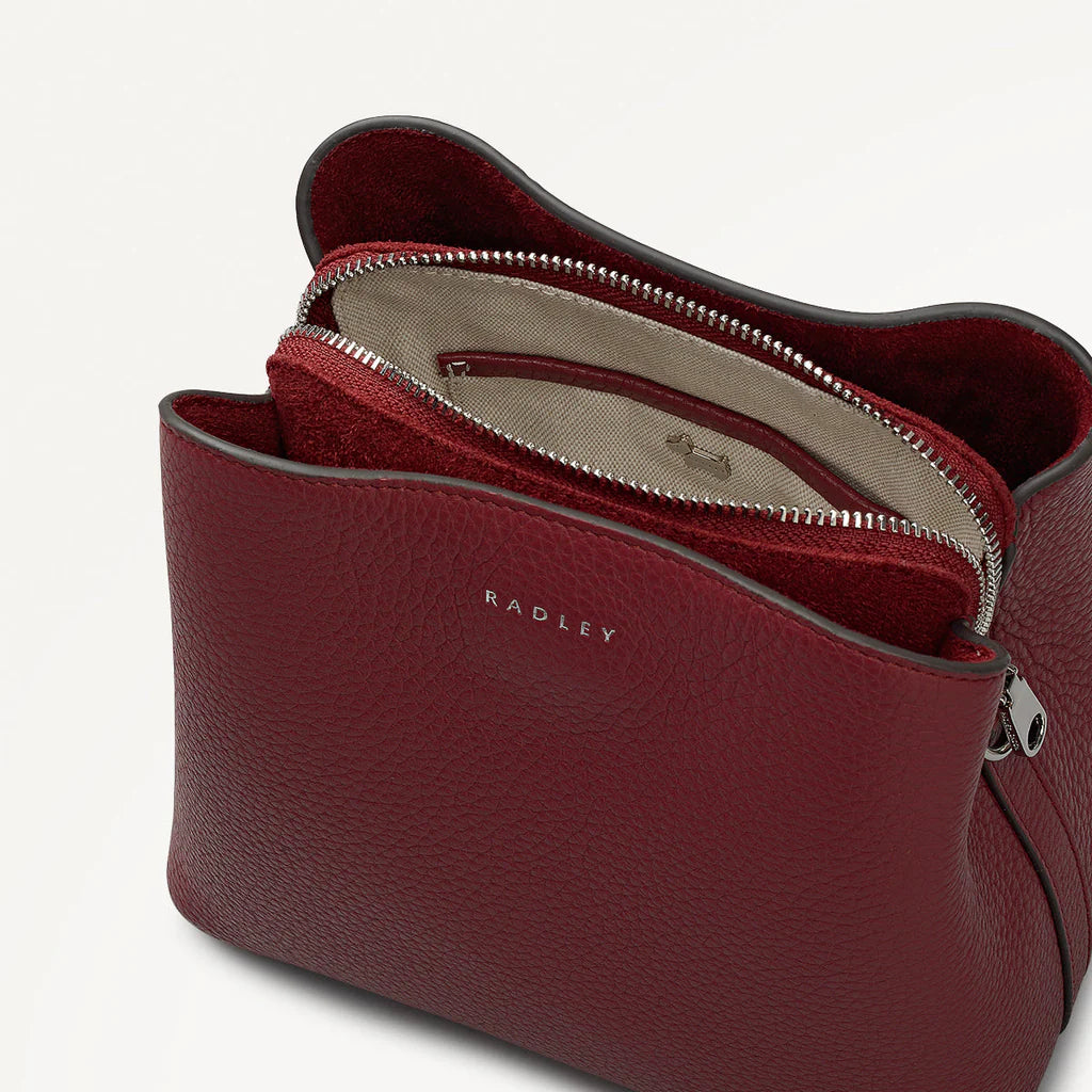 Red leather handbag with 'Radley' branding on a light gray background