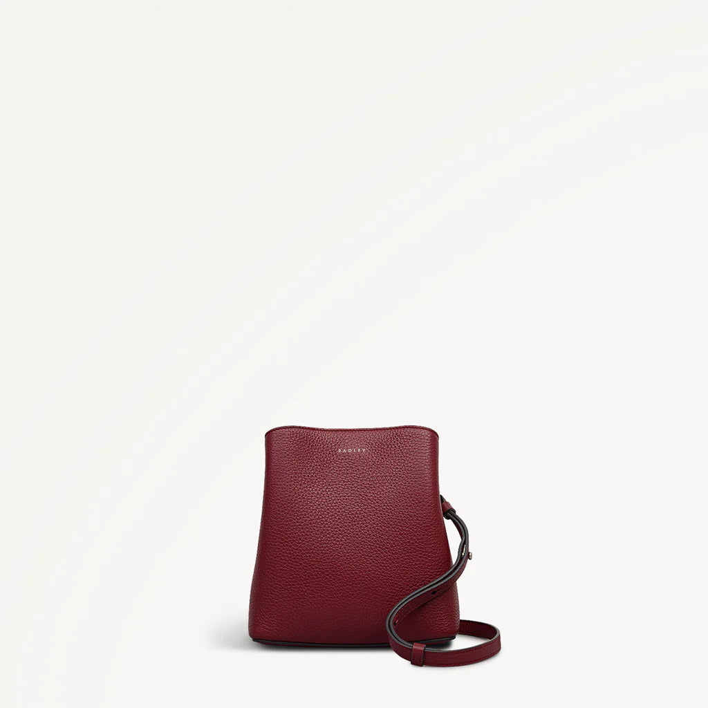 Red handbag with a strap on a white background