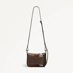 Patchwork-style handbag with a strap on a light gray background