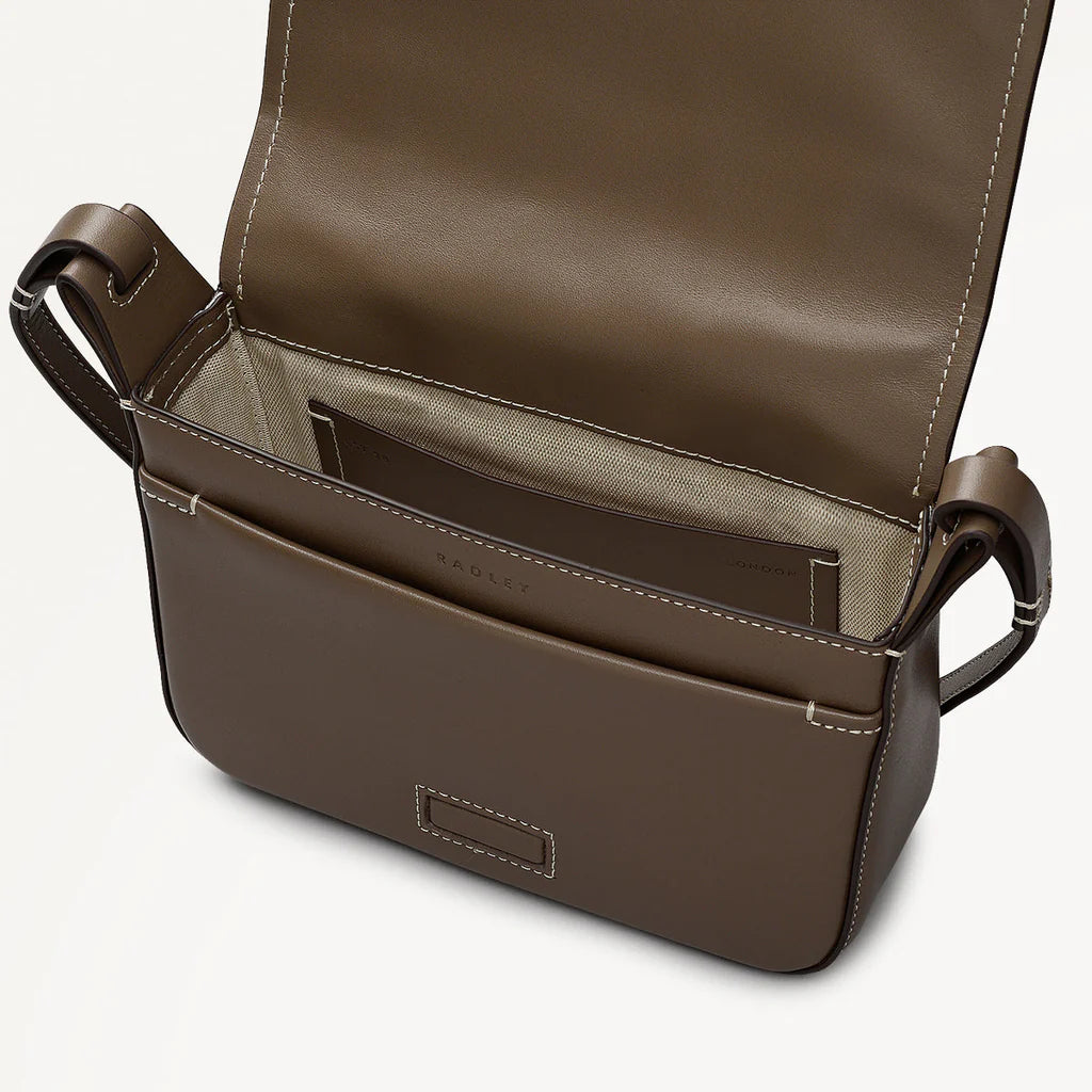 Brown leather bag with open top on a light gray background