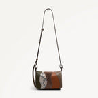 Multicolored handbag with a strap on a light gray background
