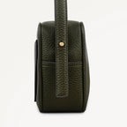 Green leather handbag with a strap on a white background