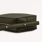 Green leather bag with a strap on a white background