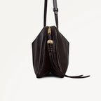 Black leather handbag with a strap on a light gray background