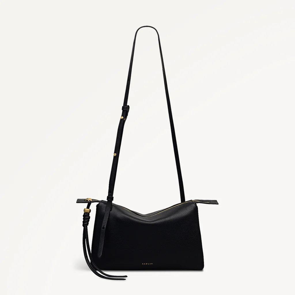 Black shoulder bag with a strap on a light gray background