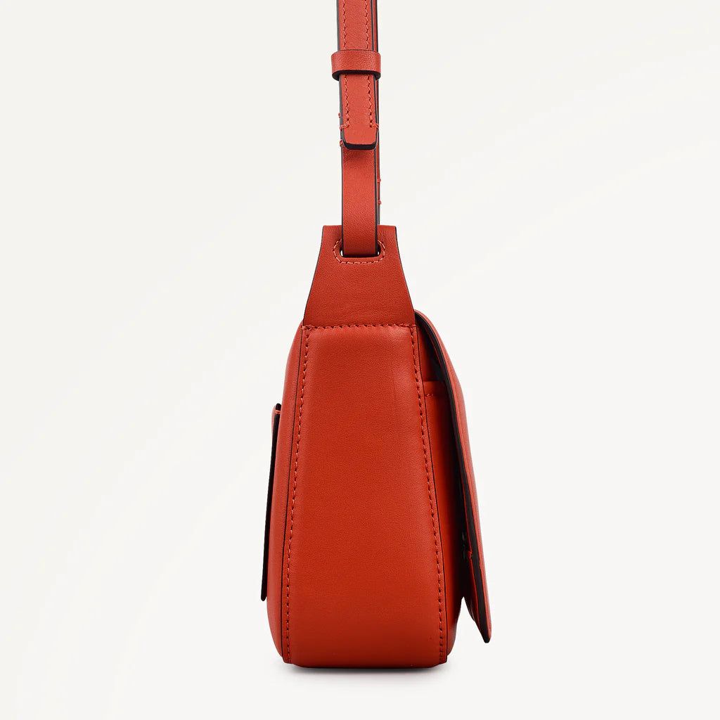 Red leather bag with a strap on a white background