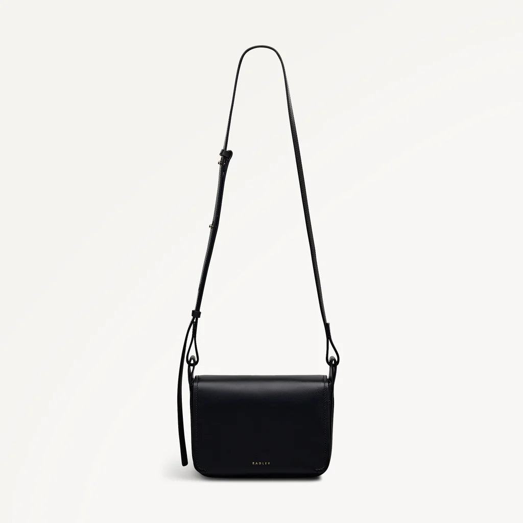 Black shoulder bag with a strap on a light gray background