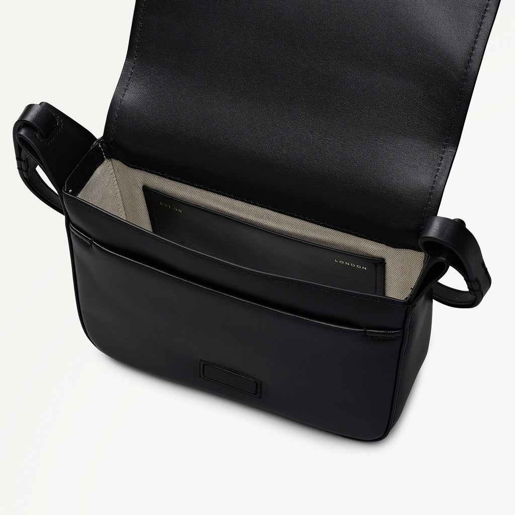 Black leather bag with visible brand logo on a light gray background