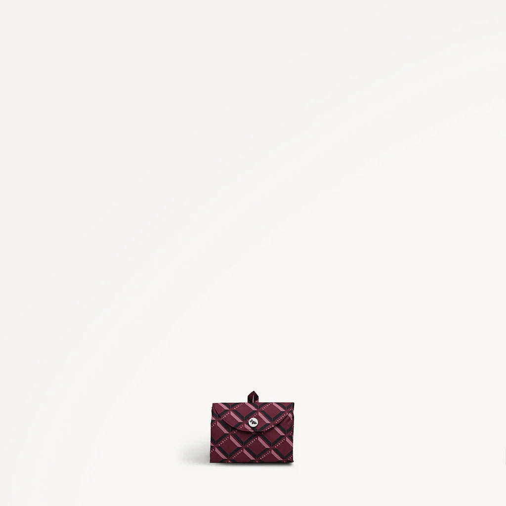 Maroon foldaway shopper folded with Radley monogram print on a light gray background