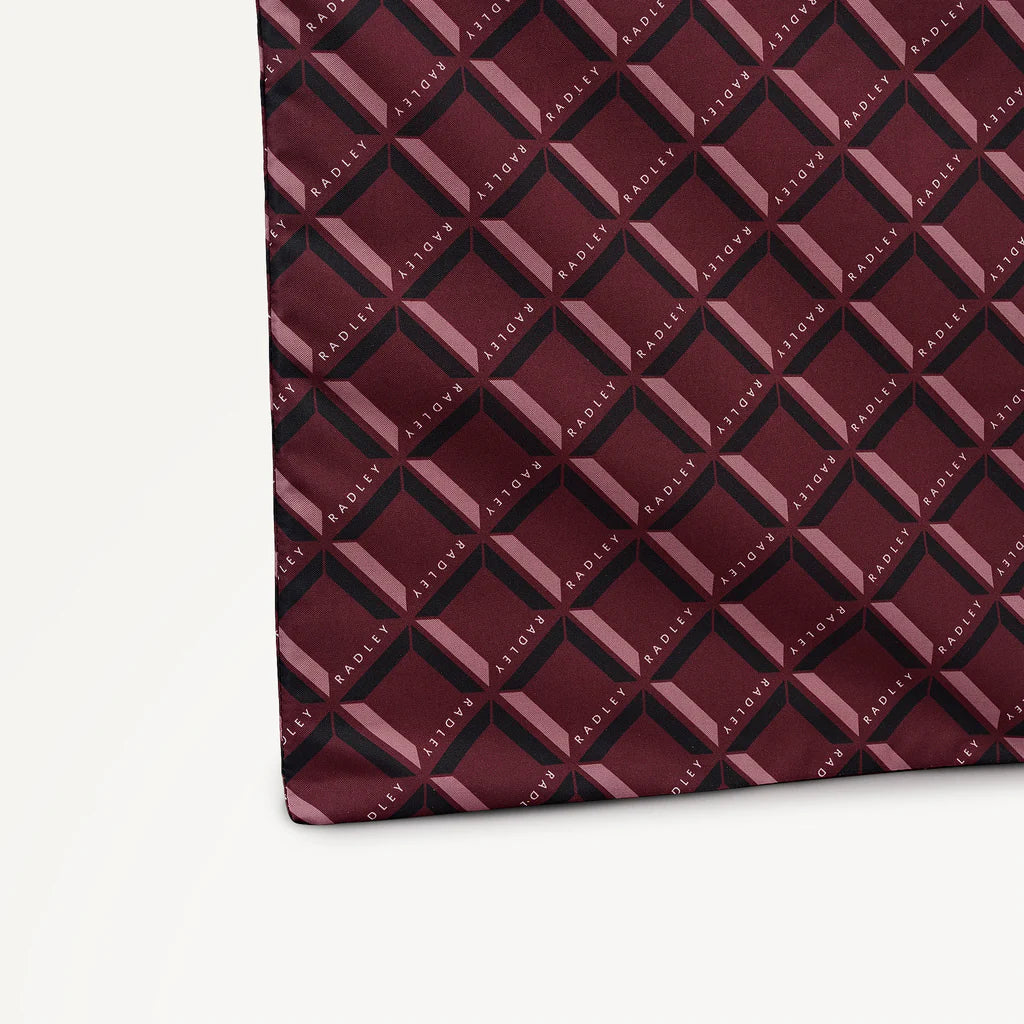 Maroon foldaway shopper  with Radley geometric monogram print on a light gray background