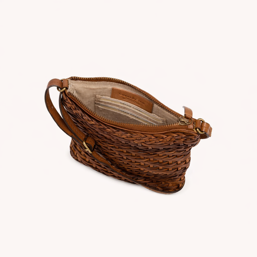 Brown woven handbag with leather accents on a white background