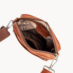 Brown leather crossbody bag with visible brand name on a white background