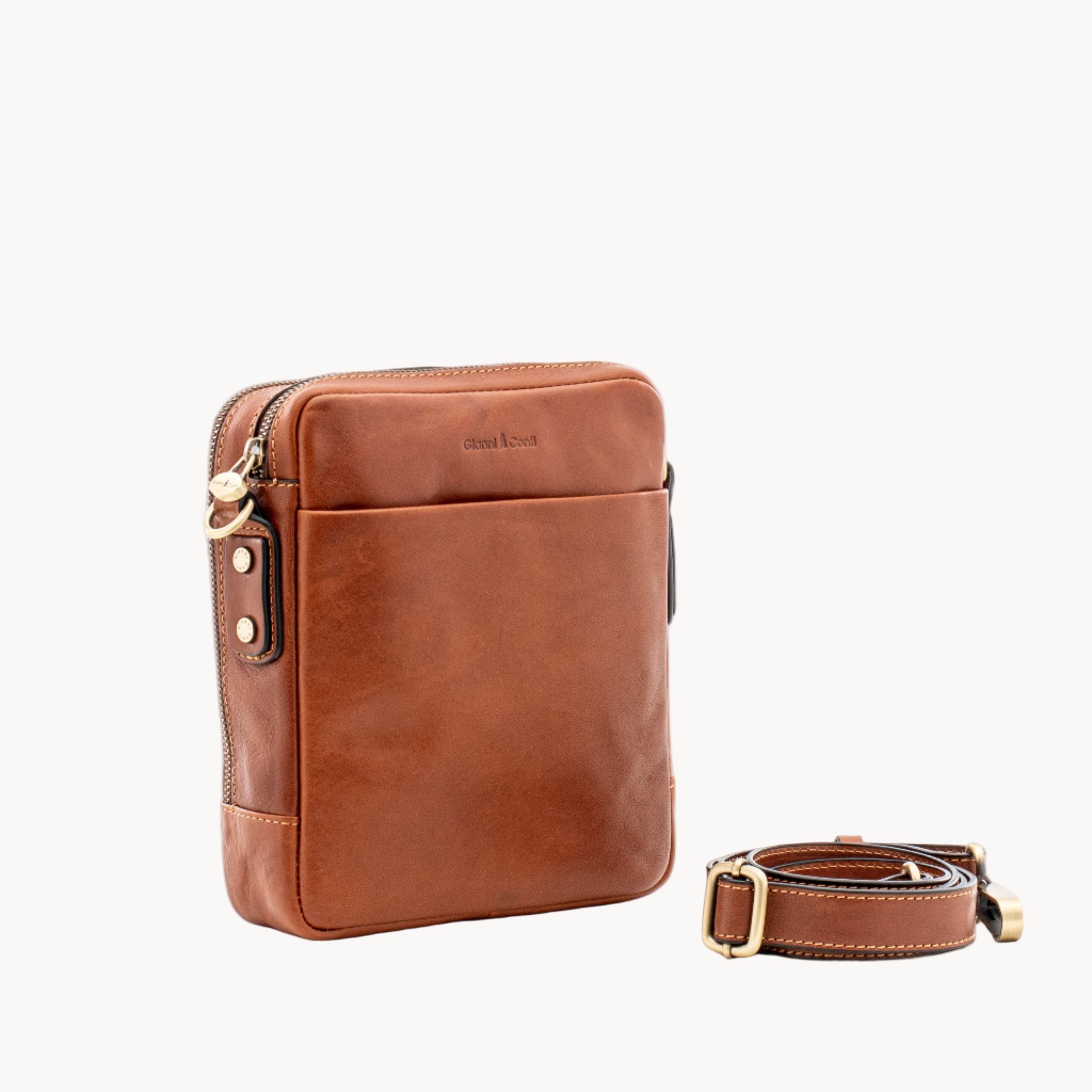 Brown leather crossbody bag with strap on a white background