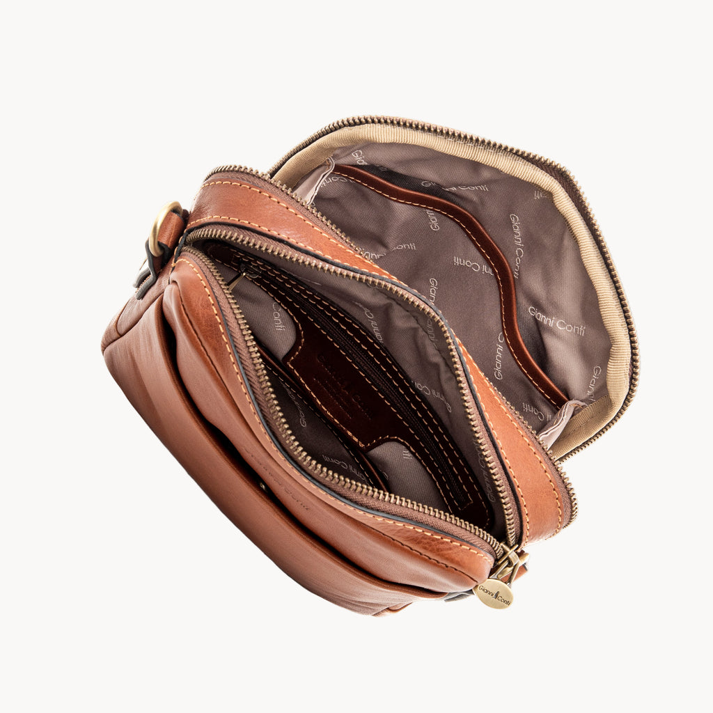 Brown leather pouch with gold zipper on a white background