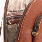 Close-up of a Tan leather bag with gold zipper and stitching details.
