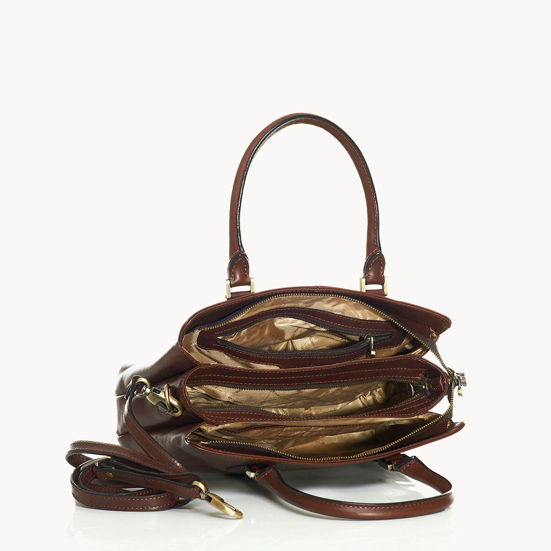Brown leather handbag with gold hardware on a white background inside view
