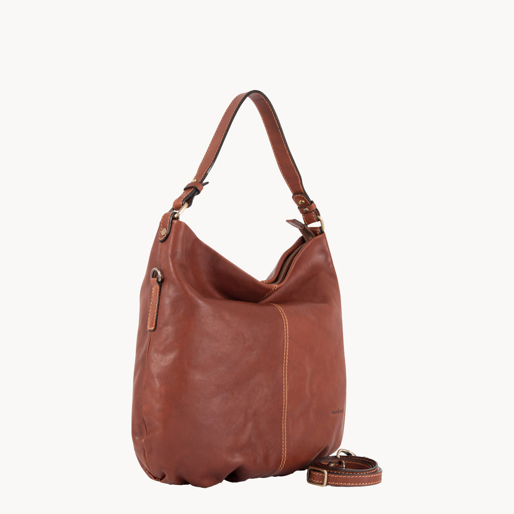 Brown leather handbag with matching strap on a white background
