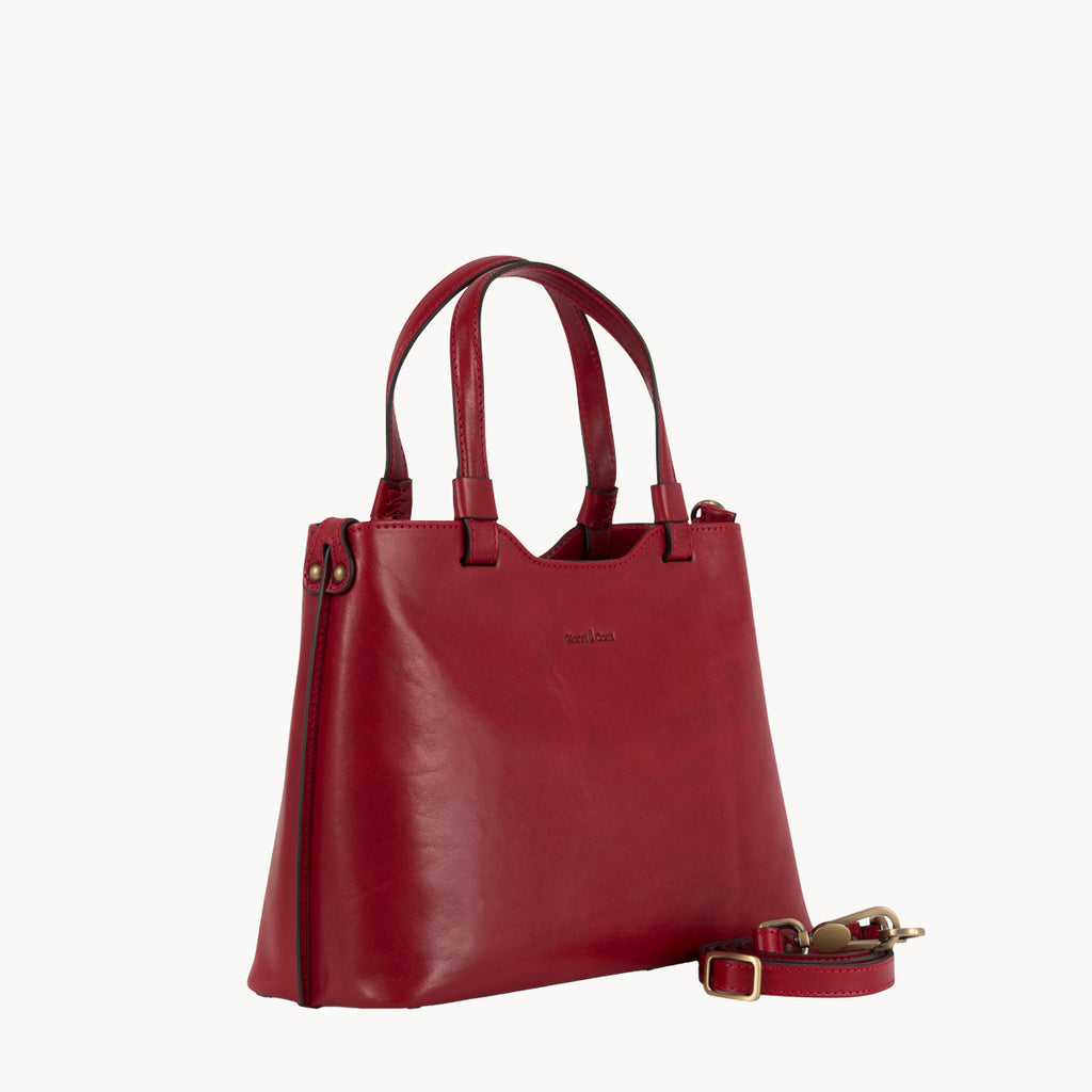 Red handbag with a strap on a white background
