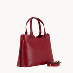 Red handbag with a strap on a white background