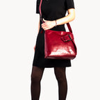 Person holding a red handbag against a white background