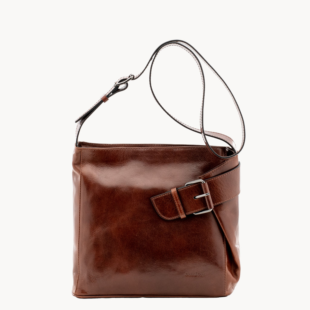 Brown leather handbag with a buckle on a white background