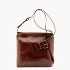 Brown leather handbag with a buckle on a white background