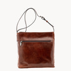 Brown leather bag with a shoulder strap on a white background