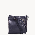 Dark blue leather handbag with a shoulder strap on a white background