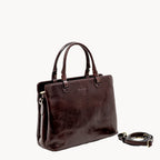 Brown leather handbag with a detachable strap on a white background