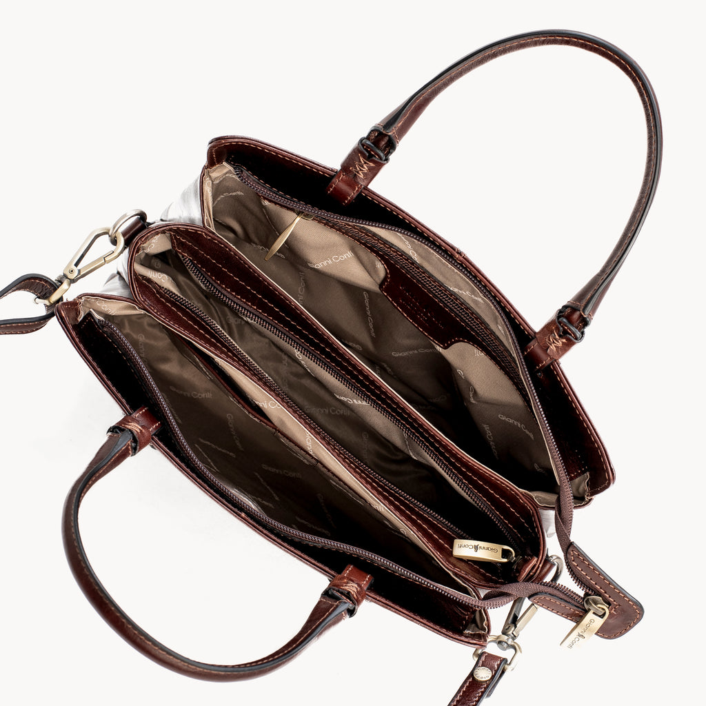 Brown leather handbag with open interior on a white background